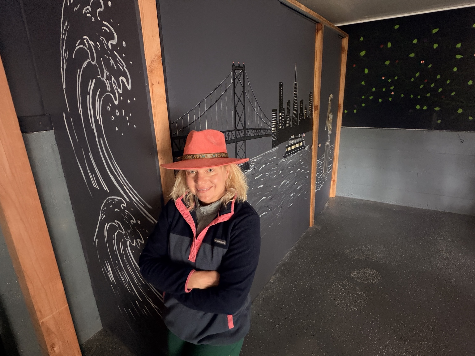Artist beside mural